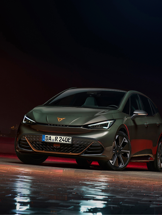 CUPRA Born VZ in Frontansicht auf nasser Fahrbahn bei Nachtstimmung